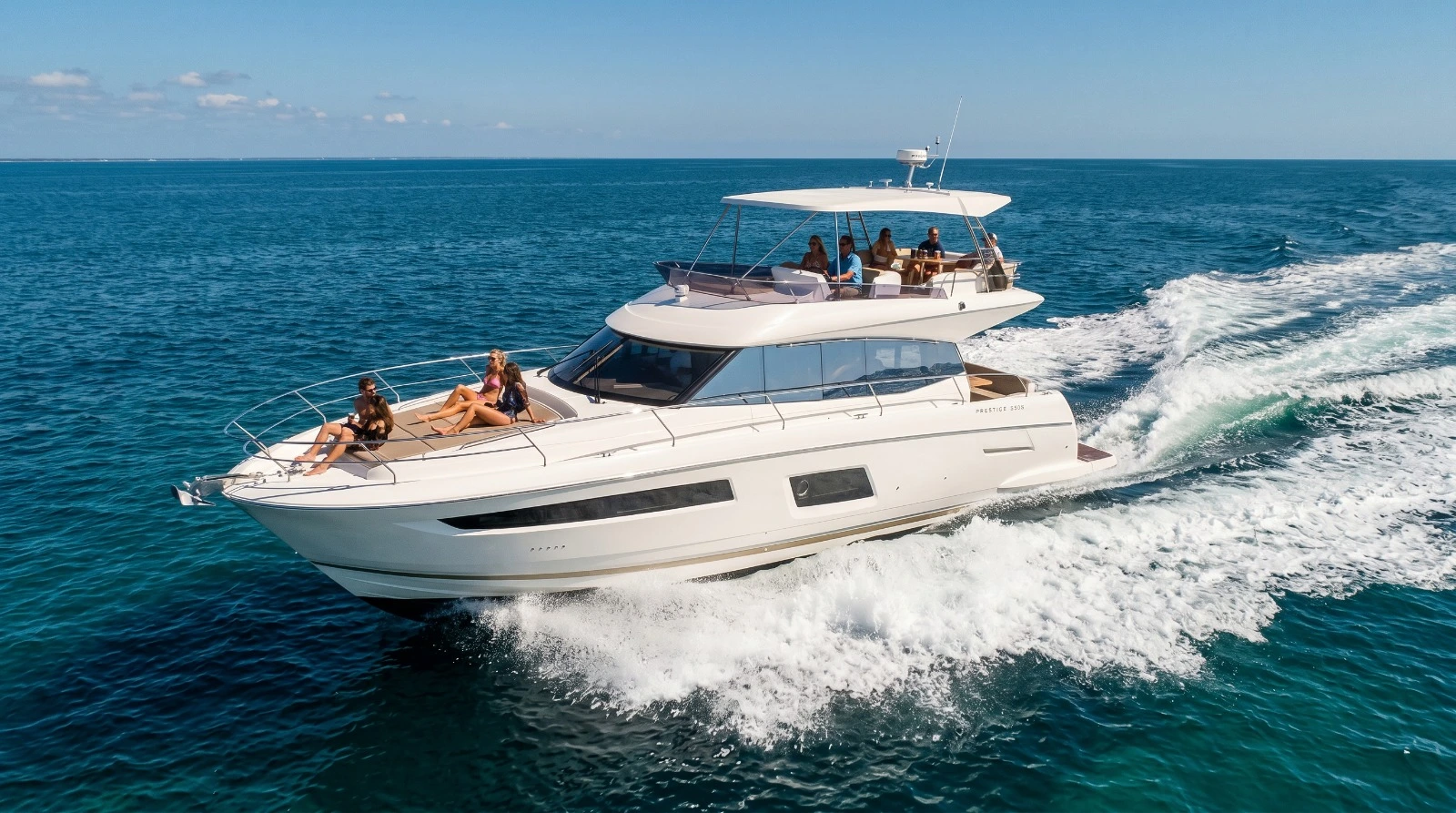 Guests aboard a Prestige 550 yacht cruising across open blue water with Zen Marine Charter in Destin